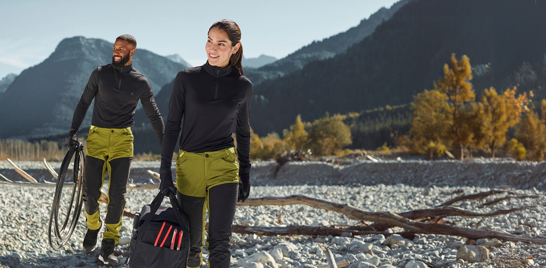 Mann und Frau tragen Hybrid Funktionshose e.s.trail in wacholdergrün / limegrün und Troyer in schwarz
